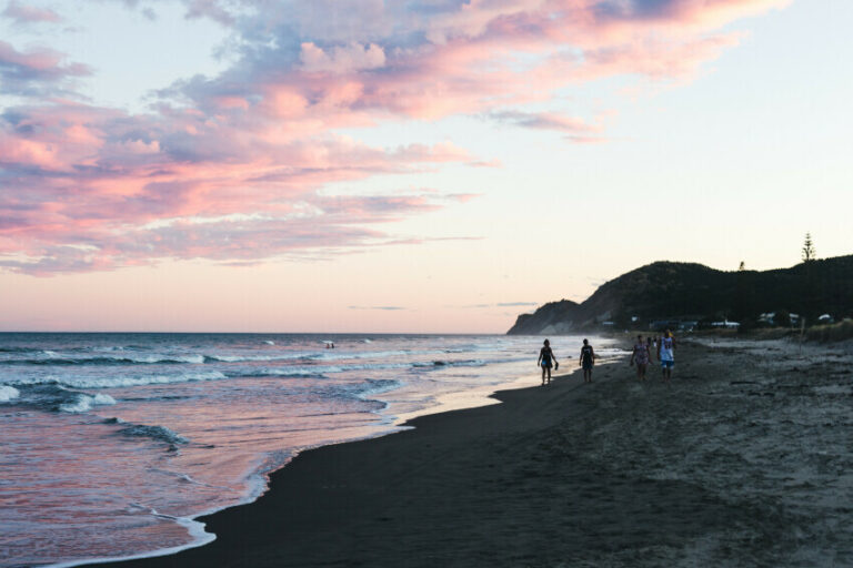 Aerial shot of a beach with pink sky in the background