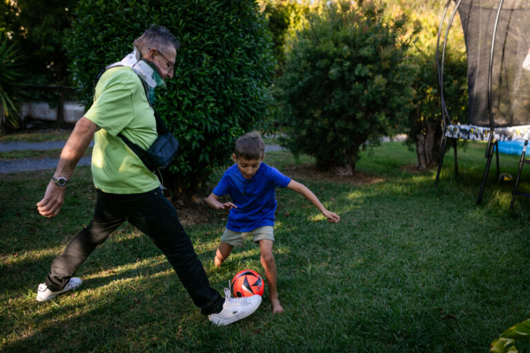 Older adult playing football with young child