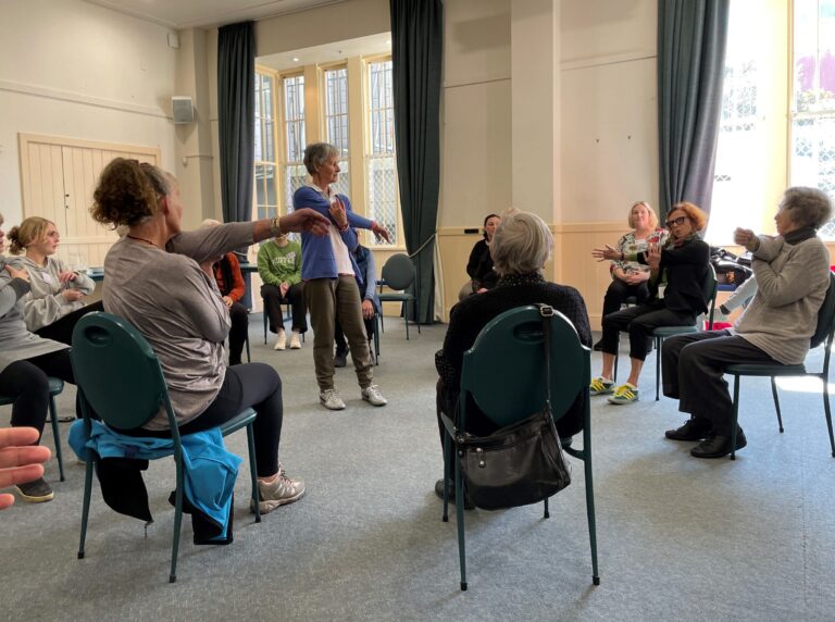 Adults in a room doing exercise