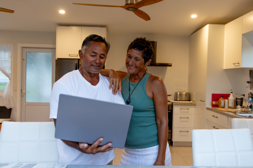 Two older adults looking at a laptop