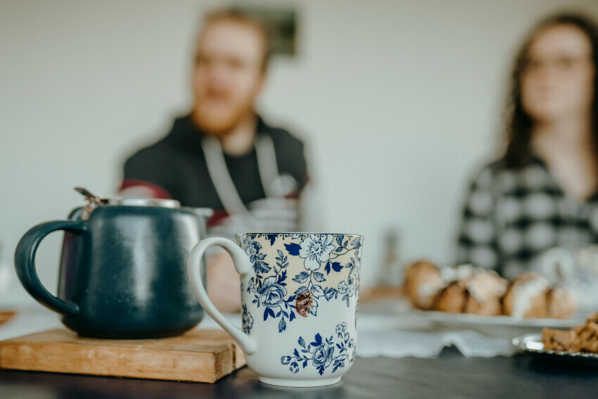 Cup and Teapot with a blurred couple in the background