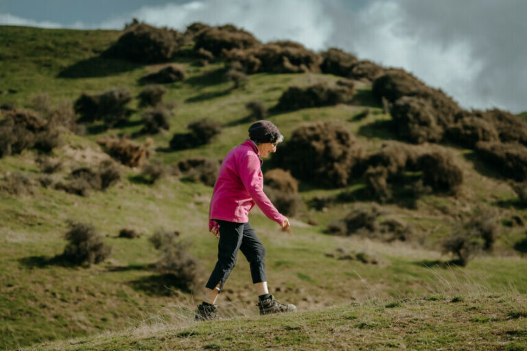 Older woman walking within the NZ landscape