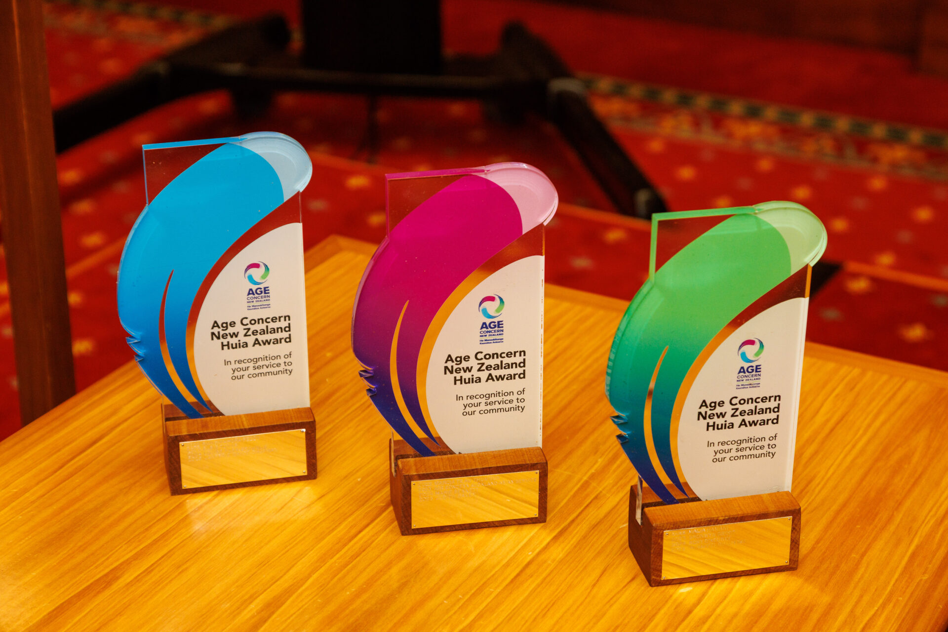 Blue huia award, purple huia award and green huia award on the table