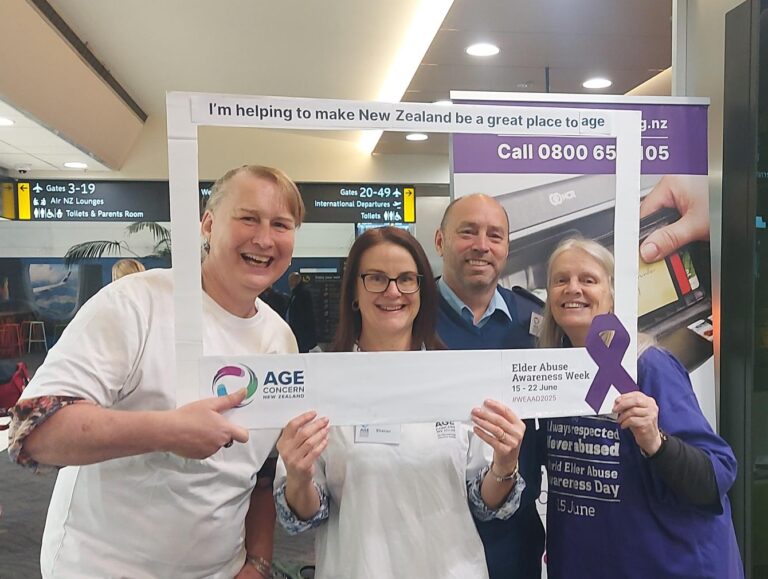 Three adults holding a sign to raise awareness for elder abuse